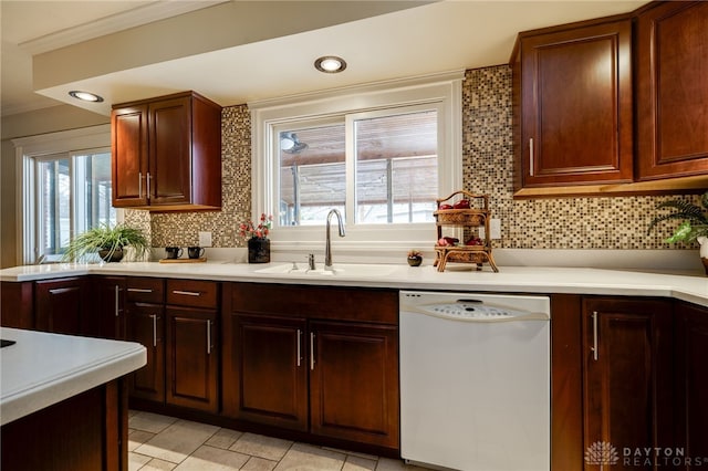 kitchen with sink, backsplash, ornamental molding, and dishwasher