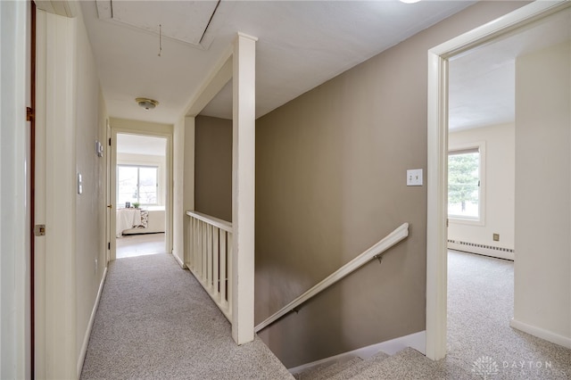 corridor featuring a baseboard radiator and light colored carpet