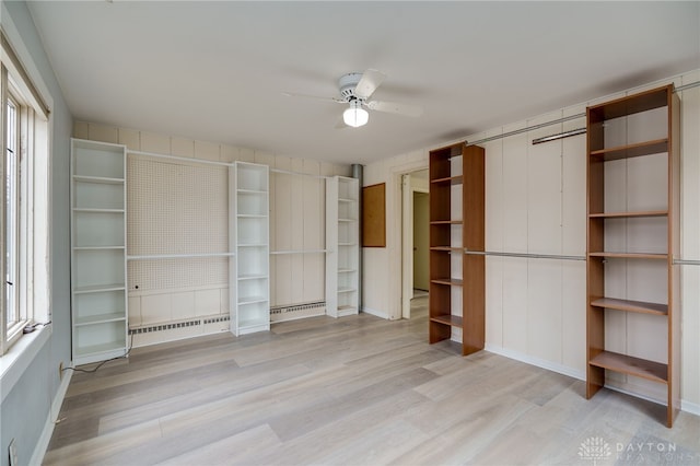 unfurnished bedroom featuring light hardwood / wood-style flooring, a baseboard radiator, and ceiling fan