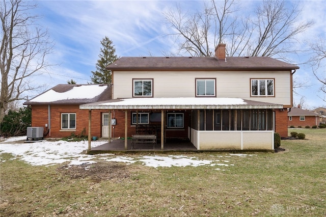 rear view of property featuring central AC, a patio area, a sunroom, and a lawn