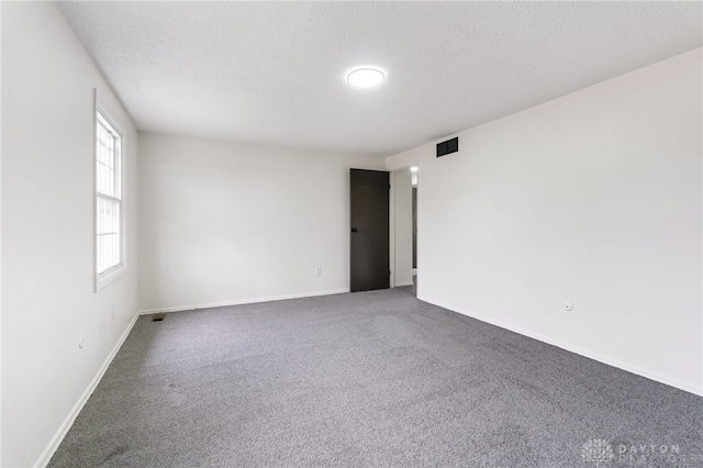 carpeted spare room featuring a textured ceiling