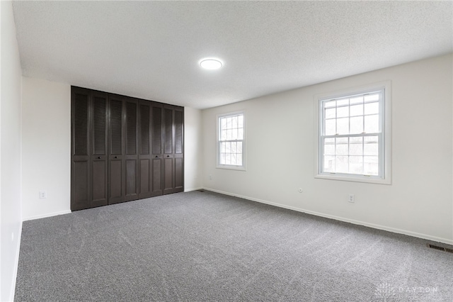 unfurnished bedroom with a textured ceiling and carpet