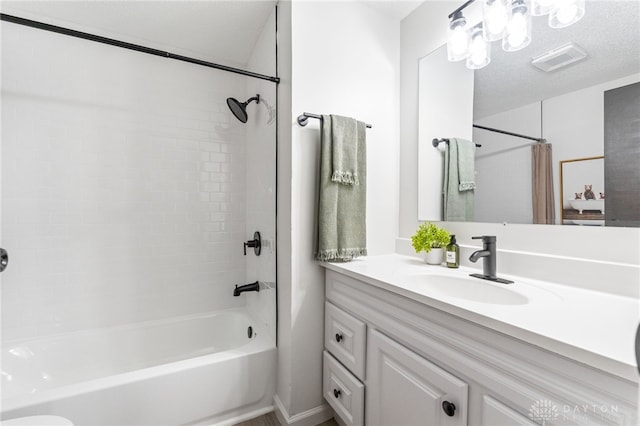 bathroom with vanity, shower / bathtub combination with curtain, and a textured ceiling