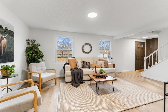 living room featuring a textured ceiling and light hardwood / wood-style floors