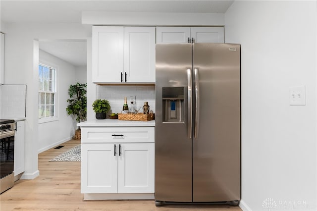 kitchen featuring white cabinetry, tasteful backsplash, and stainless steel appliances