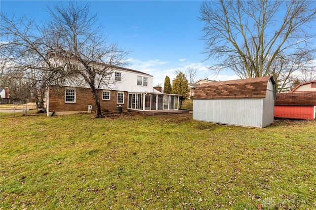 back of property featuring a storage shed, a yard, a sunroom, and central AC unit