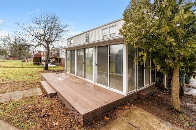 rear view of property with a wooden deck and a sunroom