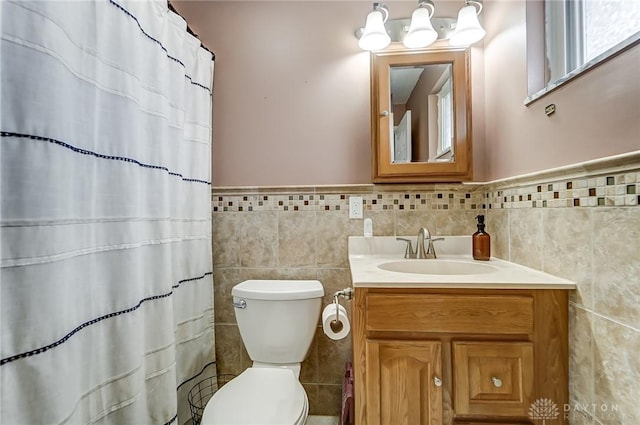 bathroom with vanity, toilet, and tile walls