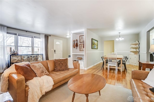 living room with a notable chandelier and light hardwood / wood-style floors