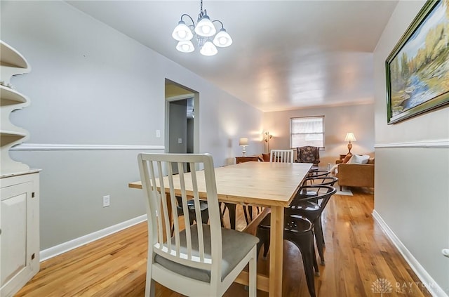 dining room with a notable chandelier and light hardwood / wood-style flooring