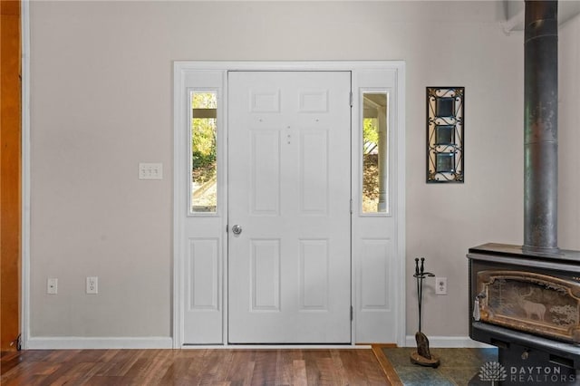 entrance foyer featuring hardwood / wood-style flooring and a wood stove