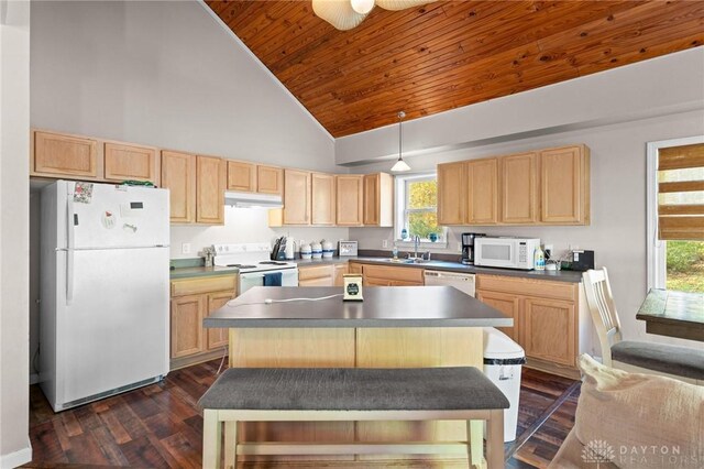 kitchen featuring a center island, pendant lighting, light brown cabinetry, and white appliances