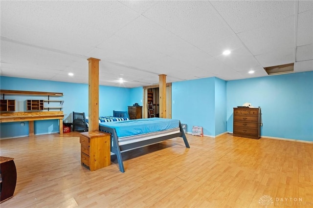 bedroom featuring a paneled ceiling and hardwood / wood-style floors