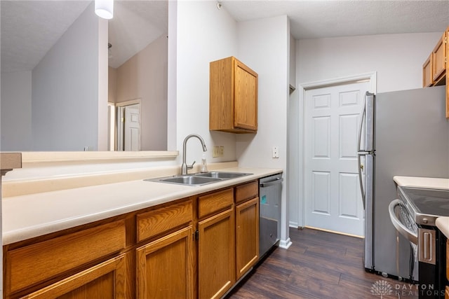 kitchen with sink, dark wood-type flooring, stainless steel appliances, a textured ceiling, and vaulted ceiling