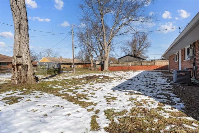 snowy yard featuring central AC