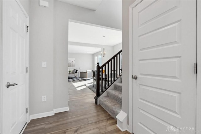 entrance foyer featuring an inviting chandelier and wood-type flooring