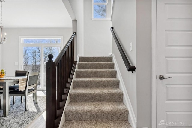 stairway featuring an inviting chandelier