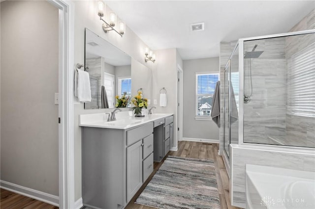 bathroom with hardwood / wood-style flooring, vanity, and walk in shower