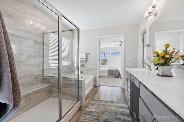 bathroom featuring vanity, wood-type flooring, shower with separate bathtub, and ceiling fan