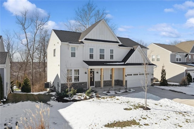 view of front of home with a porch, a garage, and central AC unit