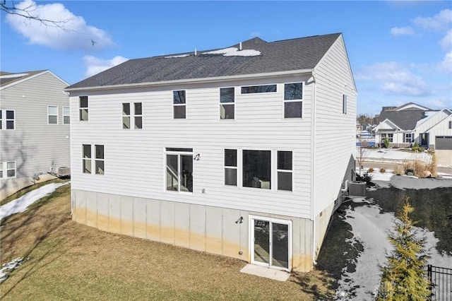 back of house with central AC and a lawn