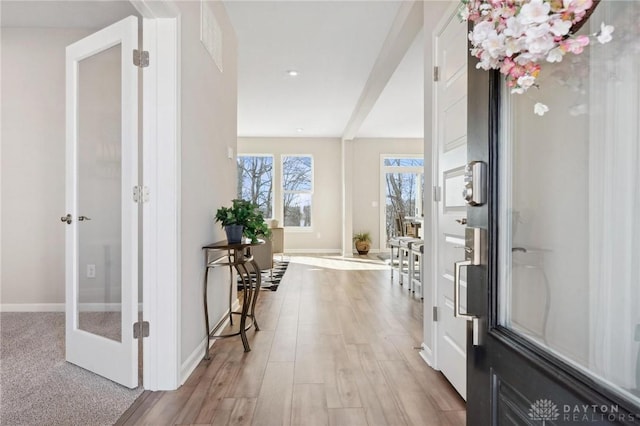 foyer entrance with light hardwood / wood-style floors and french doors