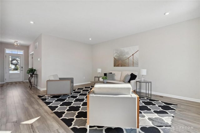 living room with hardwood / wood-style flooring and an inviting chandelier