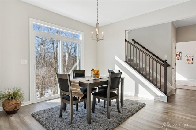 dining room with hardwood / wood-style floors and a notable chandelier