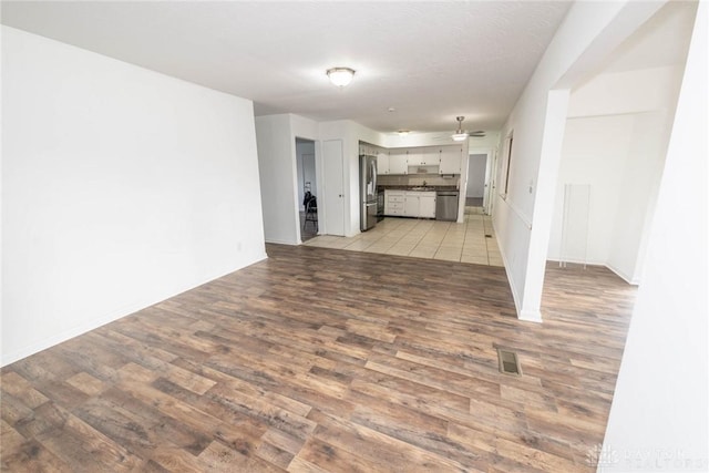 unfurnished living room with ceiling fan and light wood-type flooring