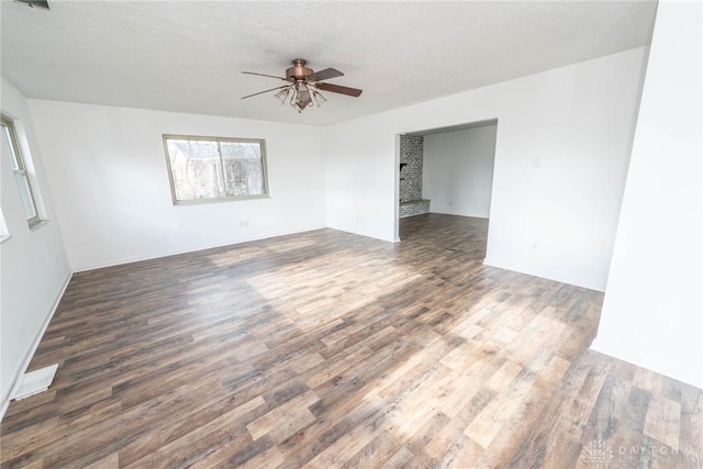 unfurnished room featuring ceiling fan, dark hardwood / wood-style floors, and a textured ceiling