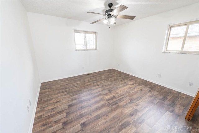 spare room with dark hardwood / wood-style floors and ceiling fan