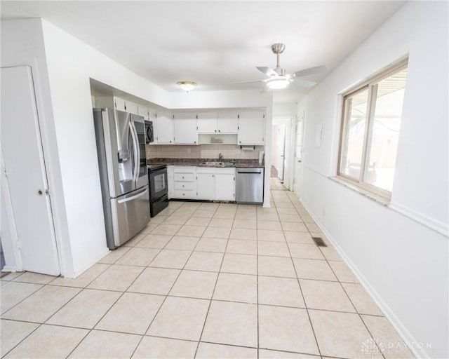 kitchen featuring light tile patterned flooring, sink, tasteful backsplash, appliances with stainless steel finishes, and ceiling fan