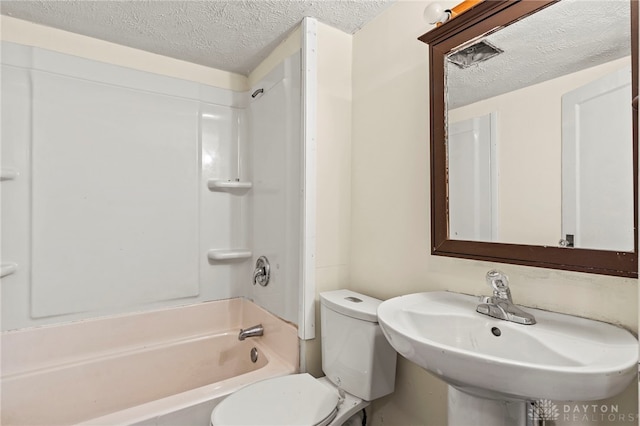 full bathroom with sink, shower / bathtub combination, a textured ceiling, and toilet