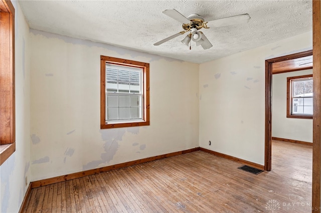 unfurnished room featuring a textured ceiling, ceiling fan, and light hardwood / wood-style flooring