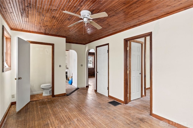 empty room featuring wood ceiling, crown molding, ceiling fan, and light wood-type flooring