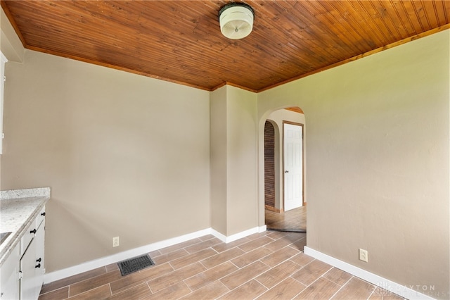700 James St, Springfield, OH 45503 - unfurnished room with arched walkways, wooden ceiling, baseboards, crown molding, and light wood-style floors