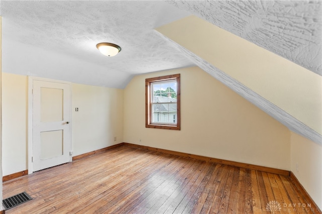 700 James St, Springfield, OH 45503 - bonus room with hardwood / wood-style floors, baseboards, lofted ceiling, and a textured ceiling