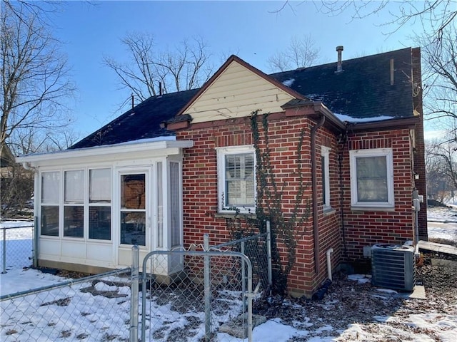 view of snowy exterior with central AC unit