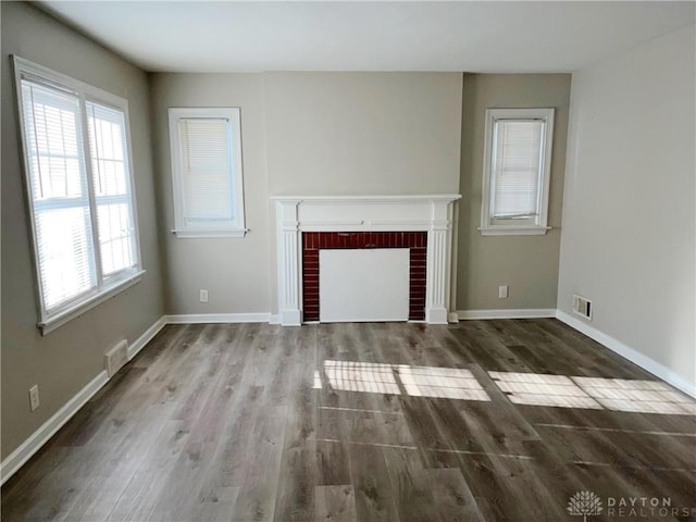 unfurnished living room featuring a fireplace and dark hardwood / wood-style flooring