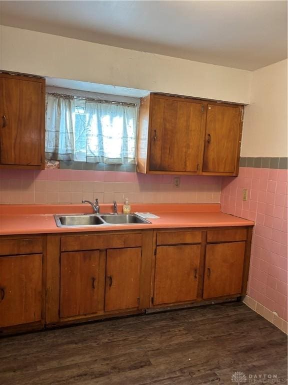 kitchen featuring dark hardwood / wood-style floors, sink, and tile walls