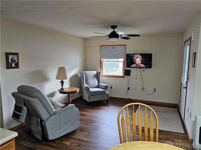 sitting room with dark wood-type flooring and ceiling fan