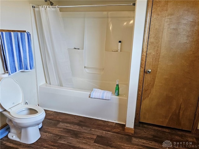 bathroom with hardwood / wood-style flooring, toilet, and shower / bath combo with shower curtain