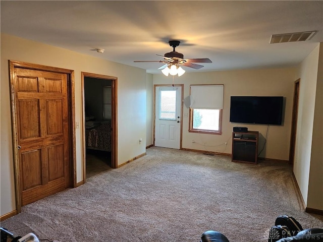 unfurnished living room with light colored carpet and ceiling fan