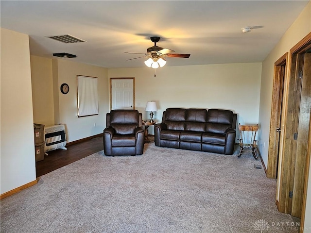 living room with ceiling fan, heating unit, and dark colored carpet