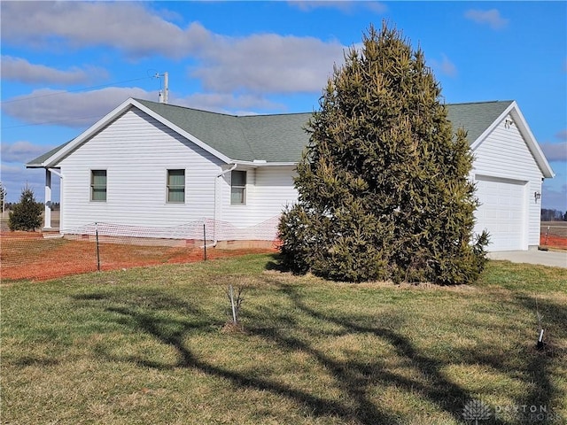 view of side of property featuring a garage and a yard