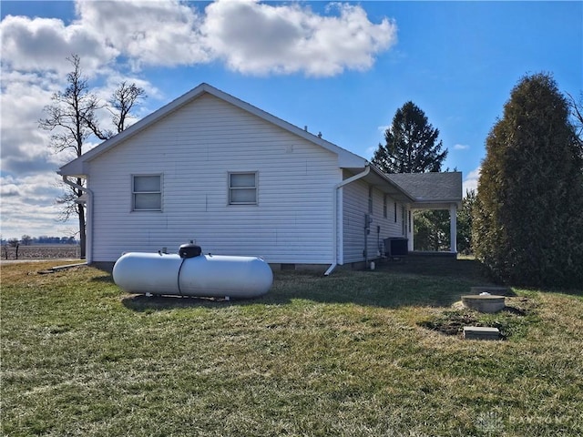 view of side of home featuring central AC and a lawn