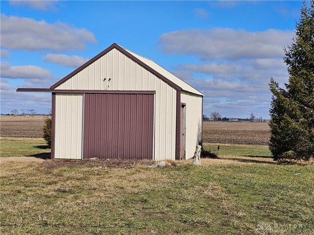 view of outbuilding featuring a lawn and a rural view