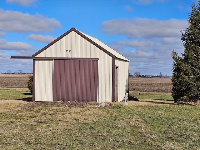 view of outdoor structure featuring a lawn and a rural view