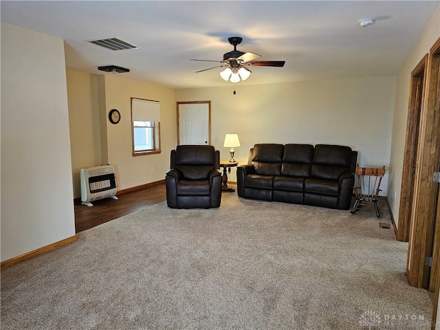 carpeted living room featuring heating unit and ceiling fan