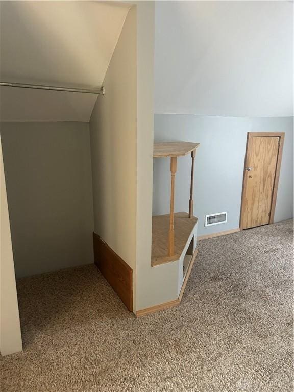 bonus room with lofted ceiling and carpet flooring